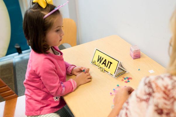 A child working with signs representing augmentative alternative communication offered by South Shore Therapies in Southern MA