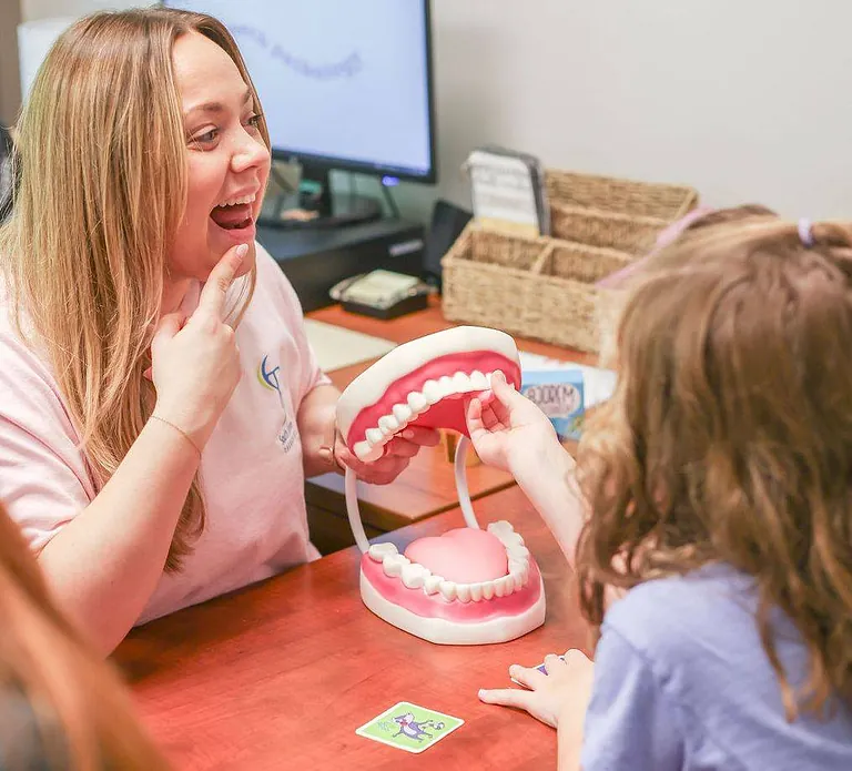 A therapist working with a young child on balance at South Shore Therapies